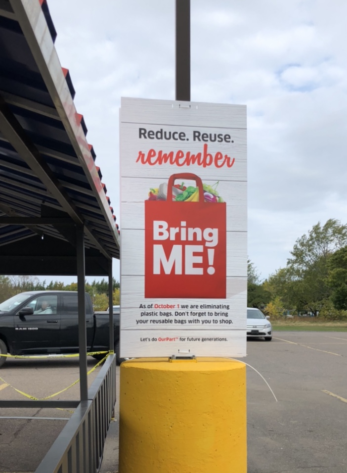 Panneau &laquo; Reduce Reuse Remember &raquo; dans un stationnement de Foodland